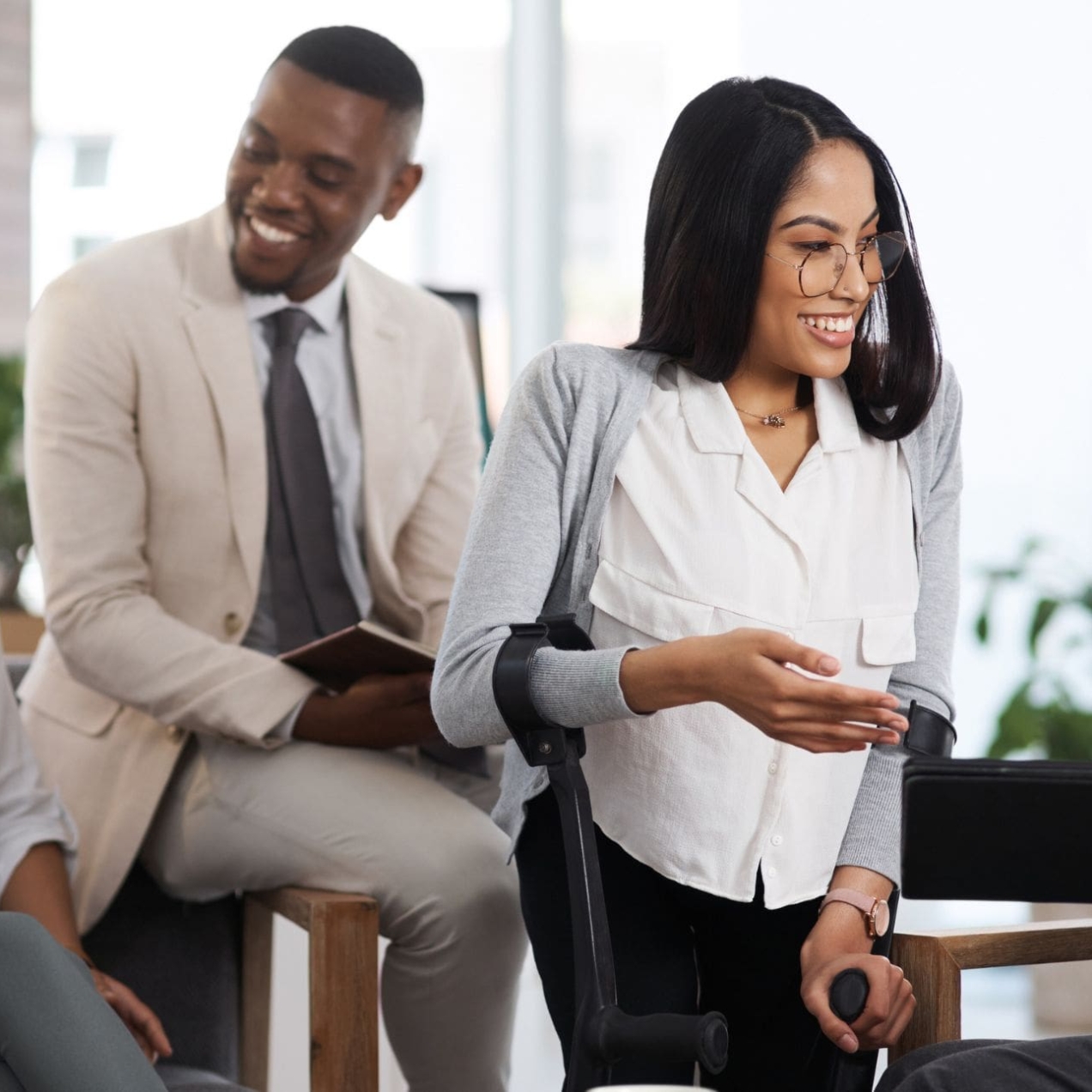 Four business colleagues - one man and three women – of different ages and ethnicities chatting in a casual office environment